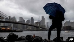ARCHIVO - Un hombre se para cerca del East River y el puente de Brooklyn, en Nueva York. (AP/Julia Nikhinson)