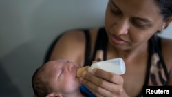 Daniele Ferreira dos Santos feeds her son Juan Pedro, who suffers from microcephaly, as they wait to be examined at the Altino Ventura Foundation, a treatment center that provides free health care, in Recife, Pernambuco state, Brazil, Feb. 4, 2016. 