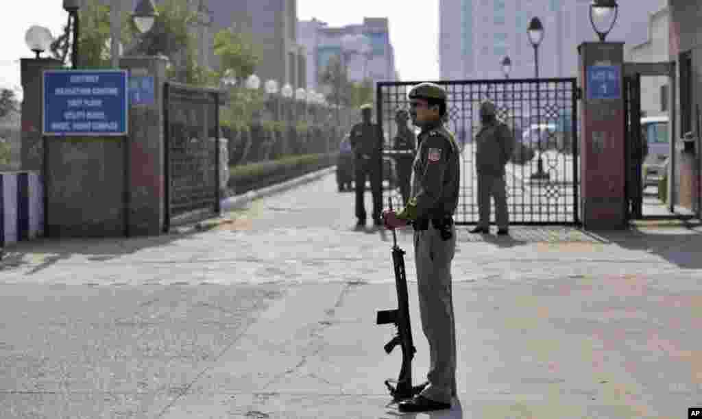 A Delhi policeman stands guard near the gate of a district court where the accused in a gang rape are undergoing trial, in New Delhi, India, January 24, 2013.
