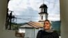 Fata Orlovic, 60, stands in front of the window in her devastated home in the village of Konjevic Polje in eastern Bosnia September 8, 2002