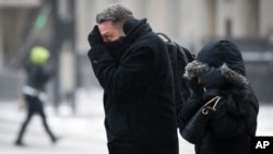 Commuters brave the wind and snow in frigid weather in Cincinnati, Ohio, Jan. 30, 2019. 