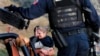 Rodeados por autoridades mexicanas fuertemente armadas, miembros de la familia LeBaron lloran en el sitio donde fueron asesinados nueve ciudadanos estadounidenses, tres mujeres y seis niños, relacionados con esa familia.
