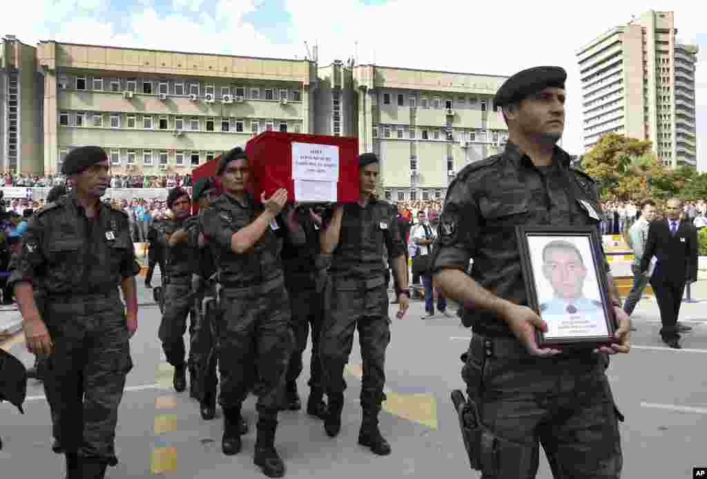 Turkish police officers carry the coffin of Turkish police special operations officer Sahin Polat Aydin, one of the four officers killed Monday in a landmine attack attributed to militants of the Kurdistan Workers' Party, or PKK, in Silopi, southeastern Turkey, during a ceremony in Ankara, Aug. 11, 2015.