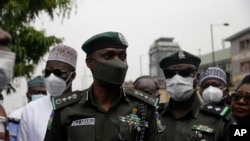 Mohammed Adamu, center, Nigeria's inspector general of police, visits a police station burned down during a recent protest to end lockdown measures against COVID-19 in Lagos, Nigeria, Nov. 3, 2020.