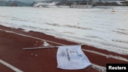 Bendera dengan logo Olimpiade Musim Dingin 2018 di tanah lokasi untuk pembangunan Stadion Olimpiade dekat Resor Alpensia di pegunungan PyeongChang, Korea Selatan. (Reuters/Pawel Kopczynski)