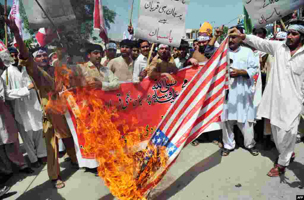 Pakistani activists of the hard line Sunni party Jamaat-e-Islami (JI) burn a US flag during a protest against an anti-Islam movie in Peshawar, September 18, 2012.