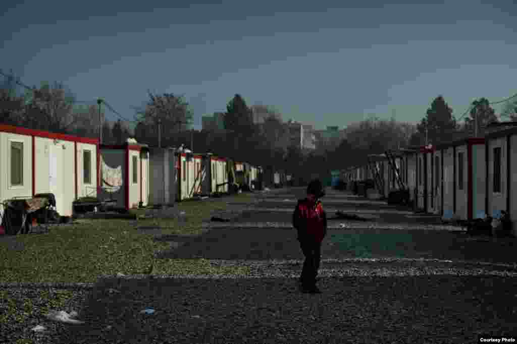 A boy enjoys a warm winter day at the closed container and tent camp in Harmanli. UNHCR/D.Kashavelov