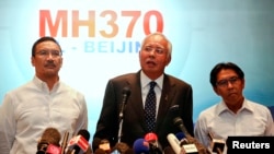 Malaysian Prime Minister Najib Razak (C) addresses reporters as Transport Minister Hishammuddin Hussein (L) and Department of Civil Aviation's Director General Azharuddin Abdul Rahman (R) stand by him, at Kuala Lumpur International Airport, March 15, 2014.