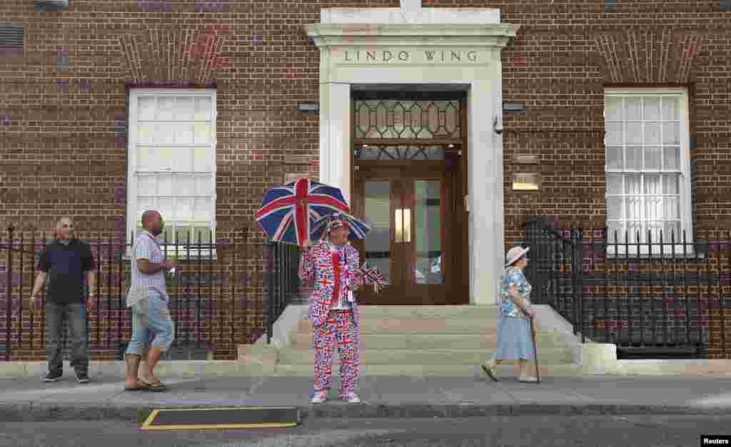 Penggemar setia anggota kerajaan menunggu di luar Rumah Sakit St. Mary's, tempat Duchess of Cambridge akan melahirkan (20/7). (AP/Suzanne Plunkett)