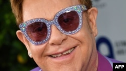 English singer-songwriter Elton John poses on the red carpet upon his arrival for the midsummer party of his AIDS Foundation, in Cap d'Antibes, near Antibes, southern France, July 24, 2019. 