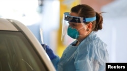 Perawat Jess White memegang hasil sapuan hidung seorang pasien di lokasi tes virus corona, flu dan RSV, di Seattle, Washington, Senin, 9 Maret 2020. (Foto: Reuters)