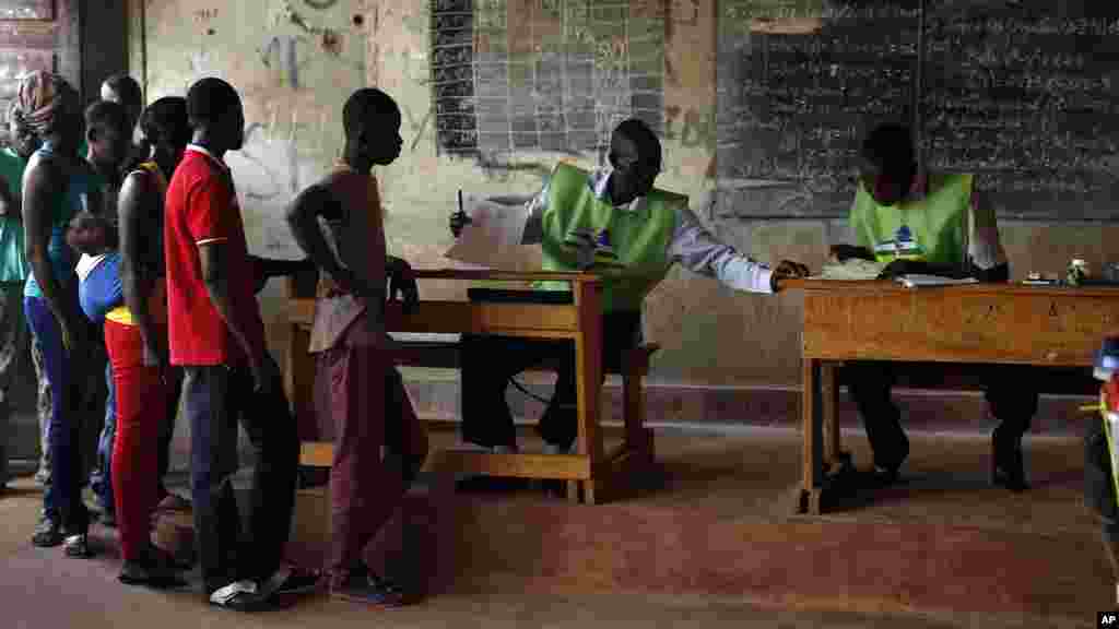 Des électeurs s’apprêtent en file à faire leur choix entre deux anciens premiers ministres, Faustin Archange Touadera et Anicet Georges Dologuele, au second tour de la présidentielle à Bangui, en République centrafricaine, 14 février 2016.