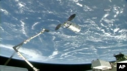 El brazo robótico de la Estación Espacial Internacional es extendido para alcanzar la nave de carga Cygnus el martes, 14 de noviembre de 2017 (260 millas) 418 kilómetros sobre la Tierra.
