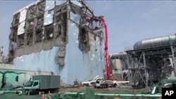 A concrete pumping vehicle sprays water on the spent fuel pool of No. 4 reactor at Tokyo Electric Power Company's Fukushima Daiichi nuclear power plant in Fukushima prefecture, May 6, 2011 (file photo)