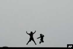 FILE - Children jump in the air at the National Museum of Korea in Seoul, South Korea, Wednesday, Sept. 20, 2023. (AP Photo/Ahn Young-joon)