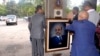 Officials move a portrait of Meles Zenawi shortly after the announcement of his death in Addis Ababa August 21, 2012. 