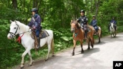 Rescuers on horseback search for a 7-year-old boy who is missing in a Japanese forest in northern Japan. He has been missing since late Saturday afternoon after his parents reportedly made him get out of the car as punishment. (Ichinoshin Matsuhashi/Kyodo News via AP