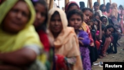 Pengungsi Muslim Rohingya antri untuk mendapatkan bantuan kemanusiaan di kamp Balukhali, dekat Cox's Bazar, Bangladesh (26/10).