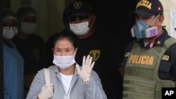 Mantan Capres Peru Keiko Fujimori, mengenakan masker untuk melindungi diri dari virus corona, melambaikan tangan kepada para wartawan saat dibebaskan dari penjara di Lima, Peru, 4 Mei 2020.