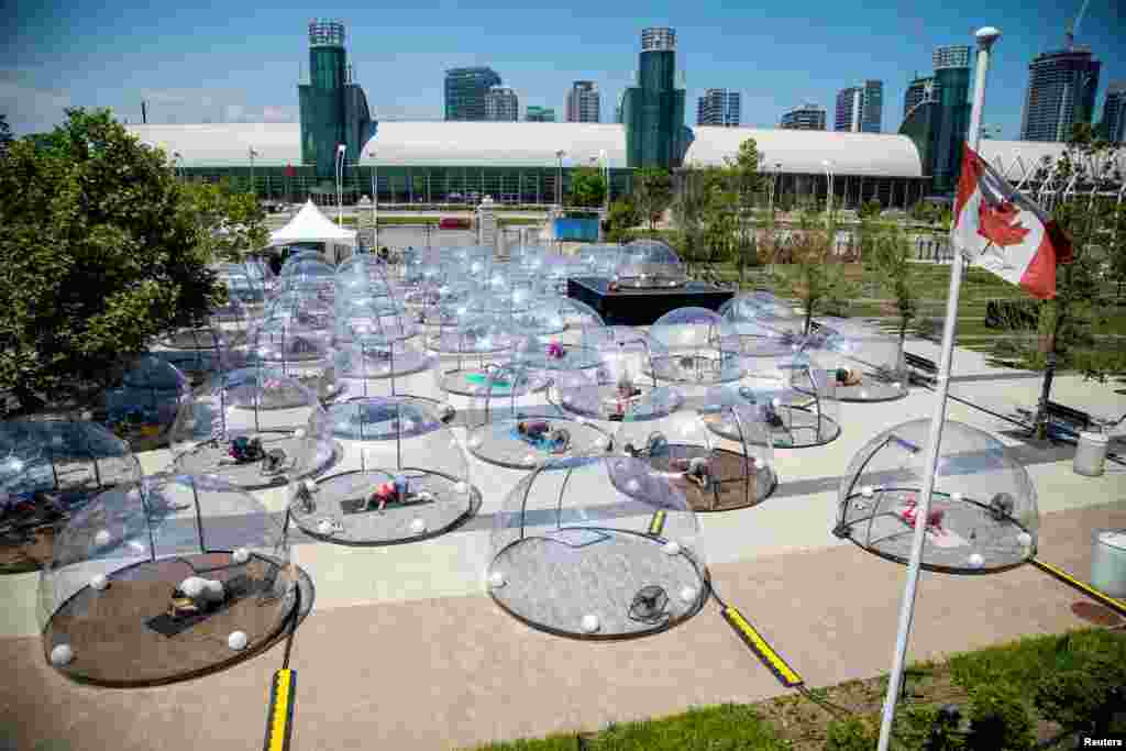 Personas participan en una clase de yoga al aire libre dentro de una cúpula para facilitar el distanciamiento social y protocolos adecuados para prevenir la propagación de la enfermedad del coronavirus (COVID-19), en Toronto, Canadá.