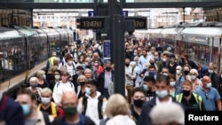 Orang-orang mengenakan masker berjalan di peron di Stasiun King's Cross di tengah pandemi COVID-19, di London, Inggris, 12 Juli 2021. 