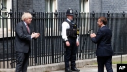 보리스 존슨 영국 총리가 18일 런던 다우닝가(Downing Street) 총리관저에서 에마뉘엘 마크롱 프랑스 대통령을 맞이했다. 두정상은 2차 세계 대전 중 프랑스의 샤를 드골 장군이 영국의 BBC 라디오를 통해 자국민들에게 독일 나치 항전을 촉구한지 80주년을 맞아 만남을 갔고 기념했다.