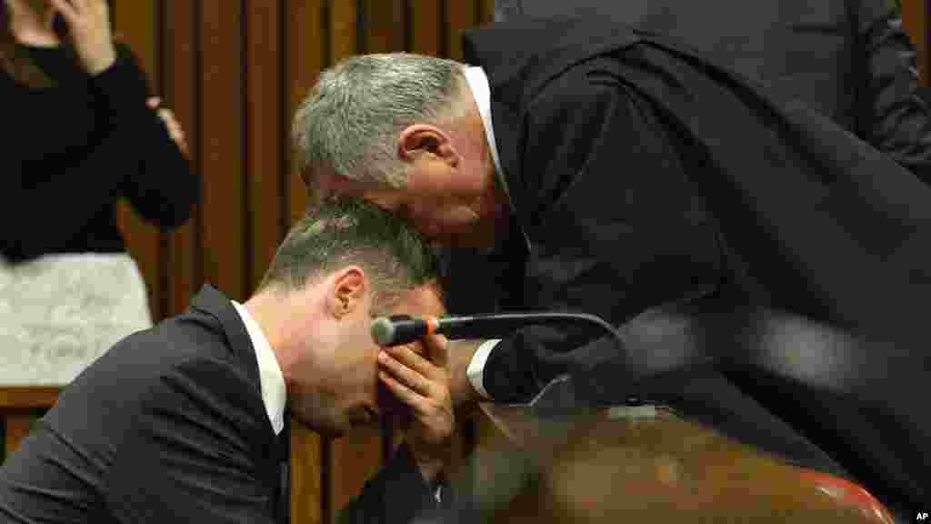 Oscar Pistorius, à gauche, en pleurs, est consolé par son avocat, Barry Roux, lors de la troisième journée d'audiences de détermination de la peine dans la haute cour à Pretoria, Afrique du Sud, le 15 octobre 2014.