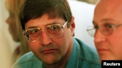 FILE - Leader of an Apartheid-era police and torture squad, Eugene de Kock (L), is seen at a hearing of the Truth and Reconciliation Commission in Pretoria Sept. 14, 1998.