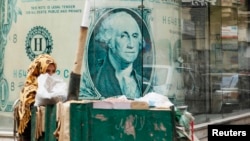 FILE - A street vendor sells seeds in front of a currency exchange bureau in Cairo in this Dec. 31, 2012.