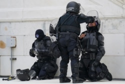 FILE - In this Jan. 6, 2021, file photo a police officer has eyes flushed with water after a confrontation with rioters at the Capitol in Washington.