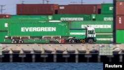 Un camionero pasa frente a contenedores en el congestionado puerto de Los Ángeles en San Pedro, California, EE. UU., 29 de septiembre de 2021.