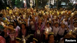 Warga Thailand memegang lilin dan foto Raja Thailand Bhumibol Adulyadej di rumah sakit Siriraj, di mana sekelompok orang berkumpul untuk merayakan ulang tahunnya yang ke-88, di Bangkok, Thailand, 5 Desember 2015.