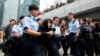 A demonstrator is taken away by policewomen from an area previously blocked by pro-democracy supporters, outside the government headquarters in Hong Kong, December 11, 2014.