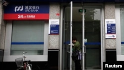 一名婦女正在離開上海浦東發展銀行開設在北京的一所支行。（路透社） 