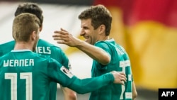 L'attaquant allemand Thomas Mueller, à droite, avec deux de ses coéquipiers lors du match amical de préparation du mondial 2018 entre l'Allemagne et l'Espagne à Duesseldorf, Allemagne de l'Ouest, 23 mars 2018