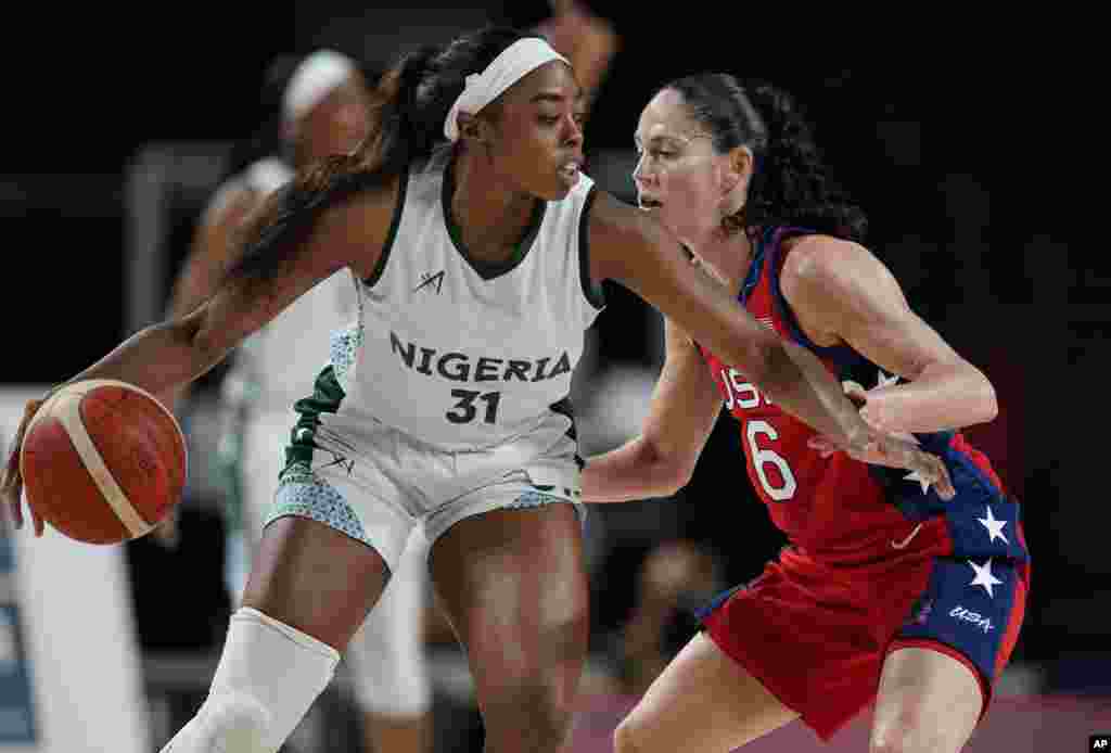 Nigeria's Erinma Ogwumike (31) drives around United States' Sue Bird (6) during women's basketball preliminary round game at the 2020 Summer Olympics, Tuesday, July 27, 2021, in Saitama, Japan. (AP Photo/Charlie Neibergall)