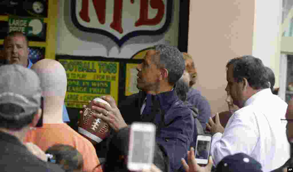 U.S. President Barack Obama, accompanied by New Jersey Governor Chris Christie, plays the 'Touch Down Fever' game on the boardwalk, Point Pleasant, New Jersey, May 28, 2013.