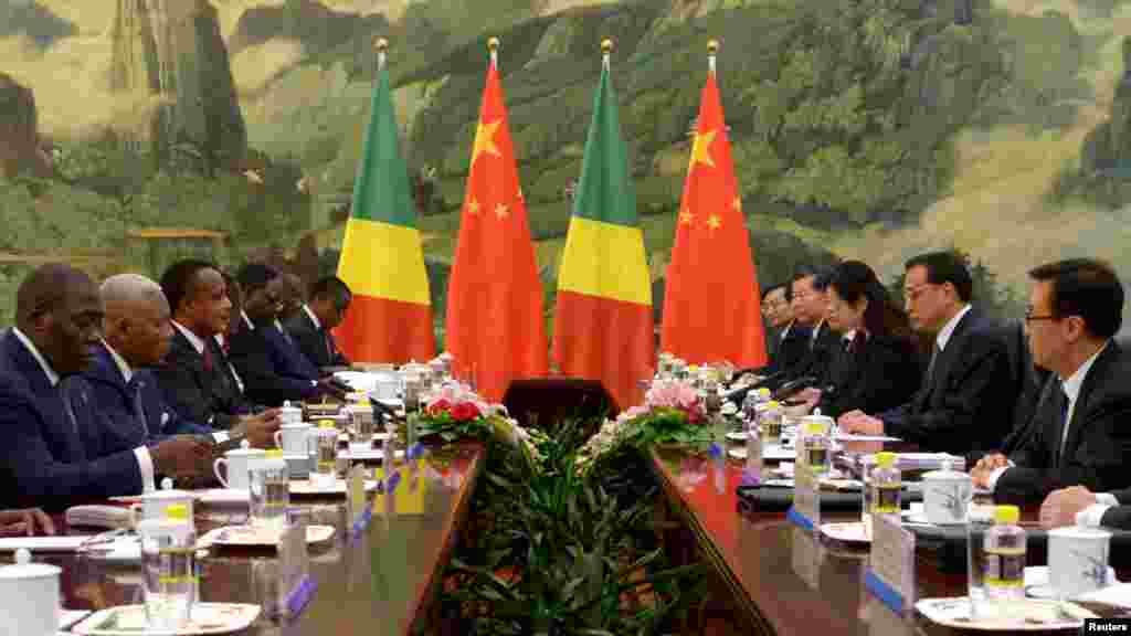 Le président de la République du Congo, Denis Sassou Nguesso (3ème gauche) à la tête d’une délégation de son pays, discute avec le gouvernement chinois conduit par le Premier ministre chinois Li Keqiang (2e droite) au Grand Palais du Peuple à Beijing, 13 juin 2014. 