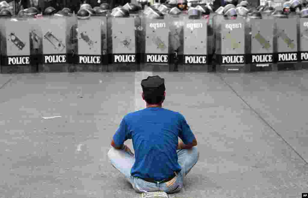 A man confronts police officers during an operation to reclaim government offices occupied by anti-government protesters on the outskirts of Bangkok, Feb. 14, 2014.