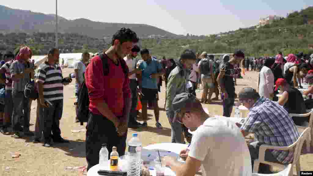 Des réfugiés et migrants s’enregistrent à un centre d'inscription à la ville de Mytilène, sur l'île grecque de Lesbos. 