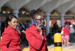 A Kenya Airways flight attendant uses her cell phone as they gather at the Jomo Kenyatta International Airport near Nairobi, Kenya, March 6, 2019.