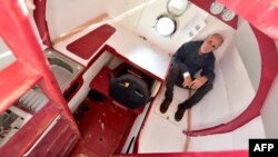 FILE - Jean-Jacques Savin, 71, sits aboard his ship made from a barrel at the shipyard in Ares, southwestern France, Nov. 15, 2018.