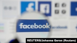 FILE - Facebook logos are seen on a screen in this picture illustration