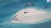 FILE - In this photo taken by surveillance planes and released May 15, 2014 by the Philippine Department of Foreign Affairs, a Chinese vessel, top center, is used to expand structures and land on the Johnson Reef, called Mabini by the Philippines and Chigua by China.