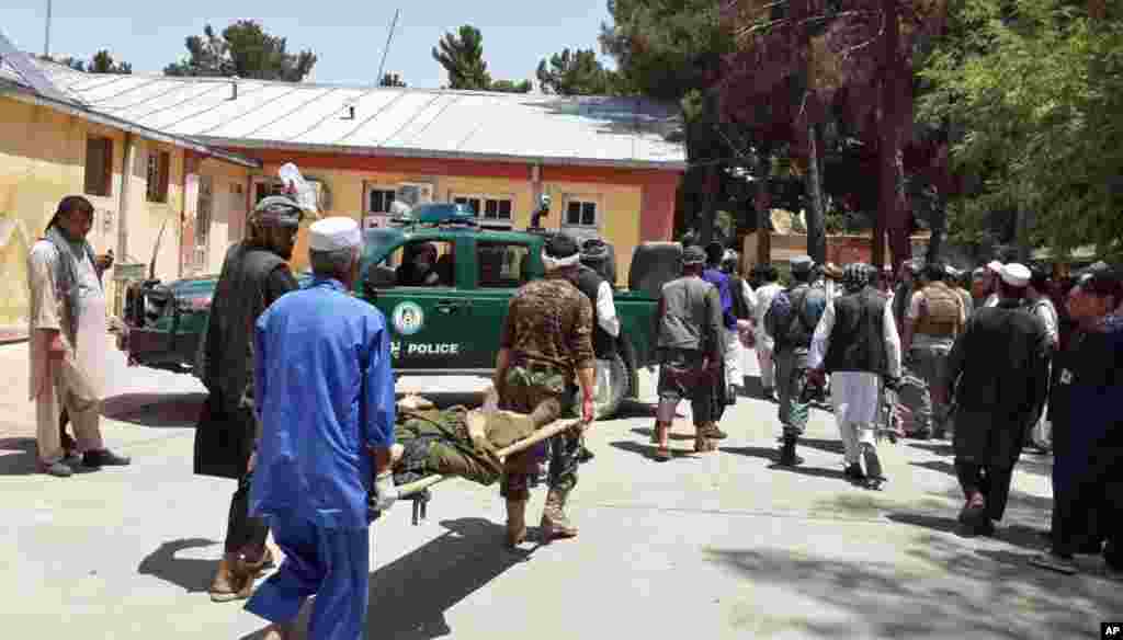 Afghan men carry an injured man to a hospital after a suicide attack in Faryab province, north of Kabul, Afghanistan, July 22, 2015.