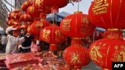 Orang-orang belanja dekorasi Tahun Baru Imlek di Fuyang, Provinsi Anhui, China, 22 Januari 2025. (Foto: AFP)