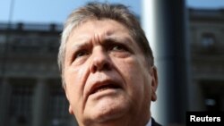 FILE - Former Peruvian president Alan Garcia talks to the media as he arrives at the National Prosecution office in Lima, Peru, March 27, 2018.