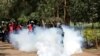 FILE - An anti-corruption protester kicks a tear gas canisters fired by Kenyan police during a protest in Nairobi, Kenya, Apr. 30, 2019. 