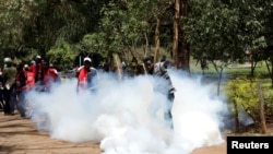 FILE - An anti-corruption protester kicks a tear gas canisters fired by Kenyan police during a protest in Nairobi, Kenya, Apr. 30, 2019. 