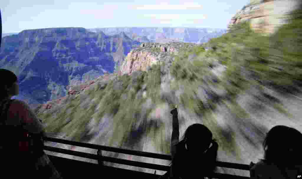 Seorang anak perempuan (tengah) tengah menyaksikan pemutaran film "Flying high over mountains" dalam pembukaan tempat hiburan visual basru di Museum Orbi Yokohama di Yokohama, dekat Tokyo, Jepang.